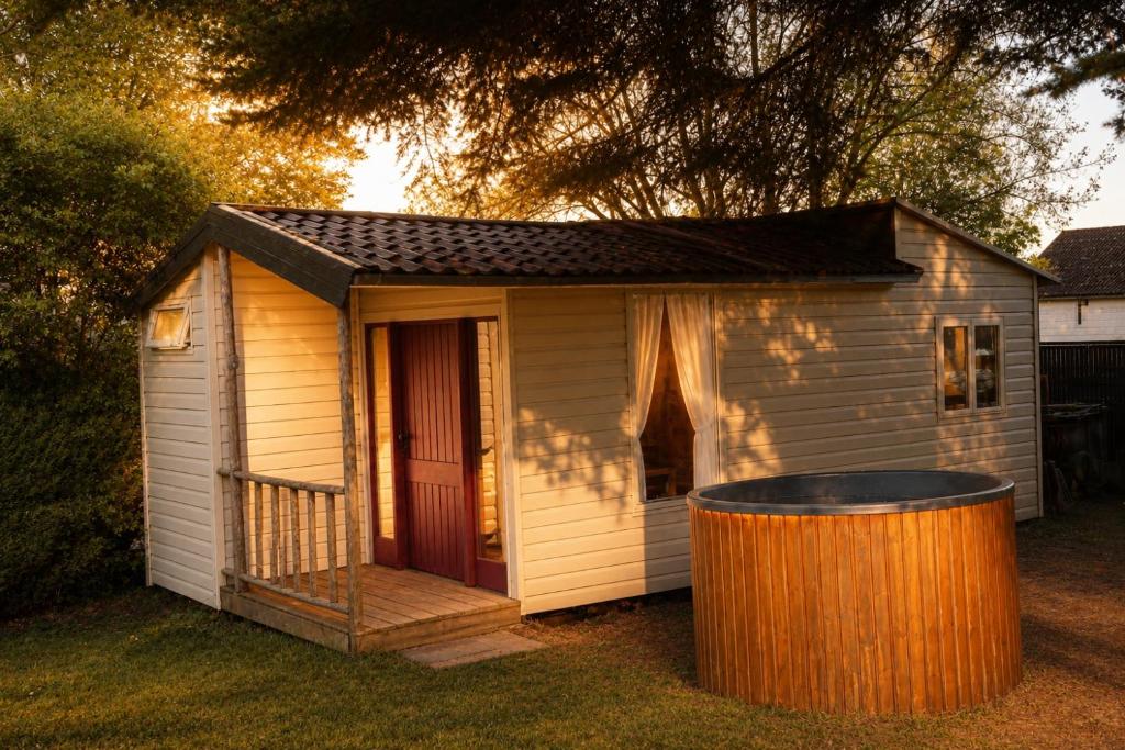 a smallshed with a trash can in front of it at Tiny house met Coldtub 4pers The Firefly in Amblève