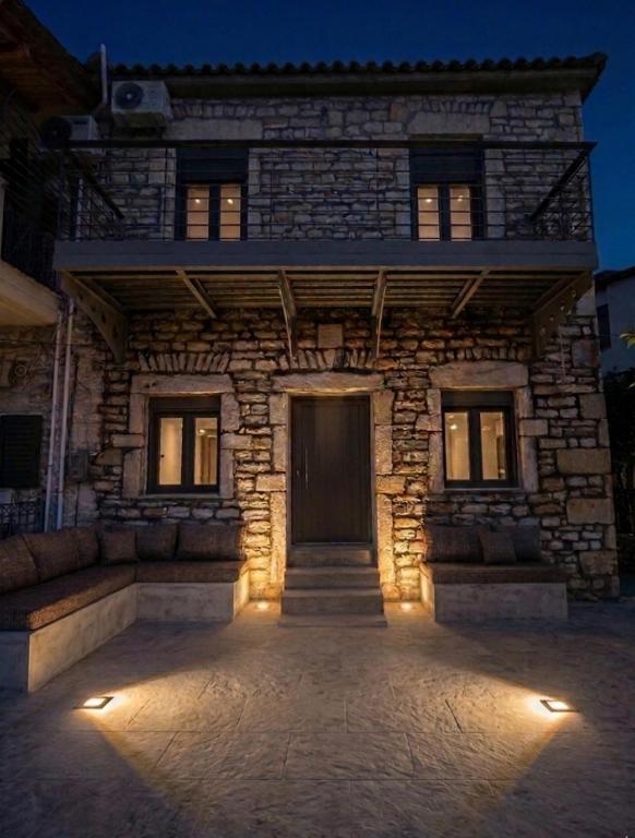 a stone building with a front door at night at Geamare Studios in Kálamos