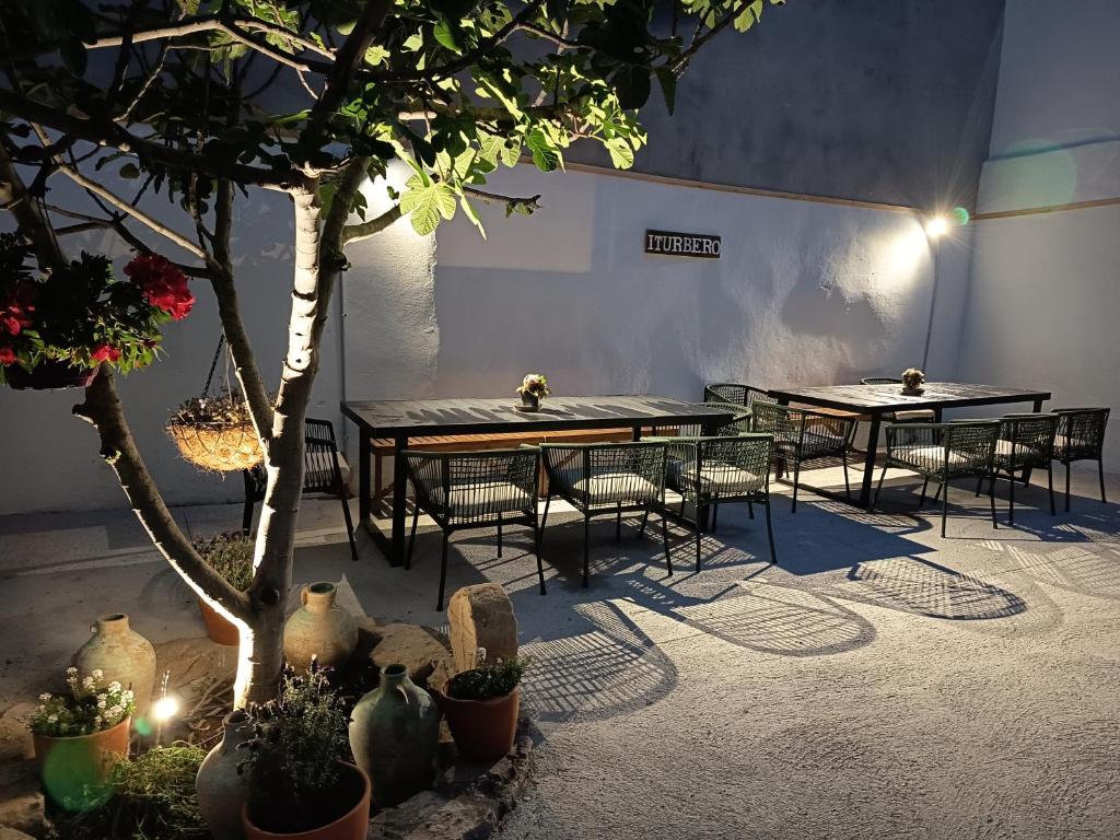two tables and chairs in a room with plants at Casa Rural Garcés in Lumbier