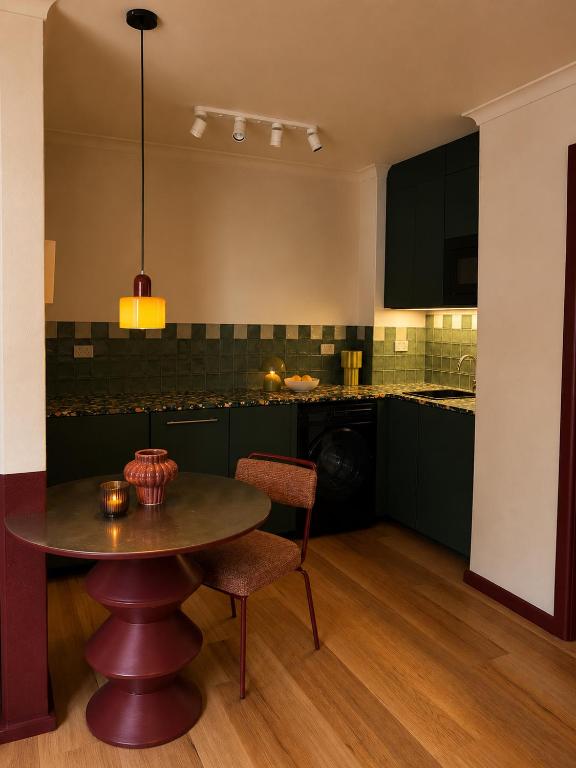 a kitchen with a table and a dining room at The Bron Apartment - newly renovated, designer stay in Yarralumla