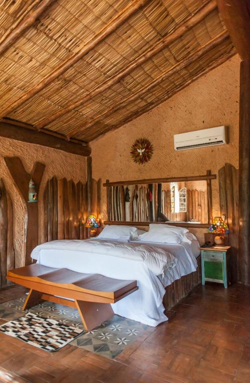 a bedroom with a large bed and a wooden ceiling at Pousada pegada da onça in Tapiraí
