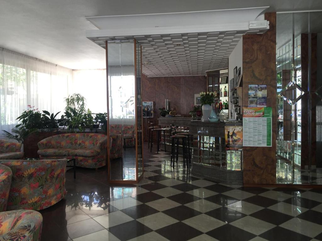 een lobby met een geruite vloer en een bar bij Hotel Calypso in Bellaria-Igea Marina