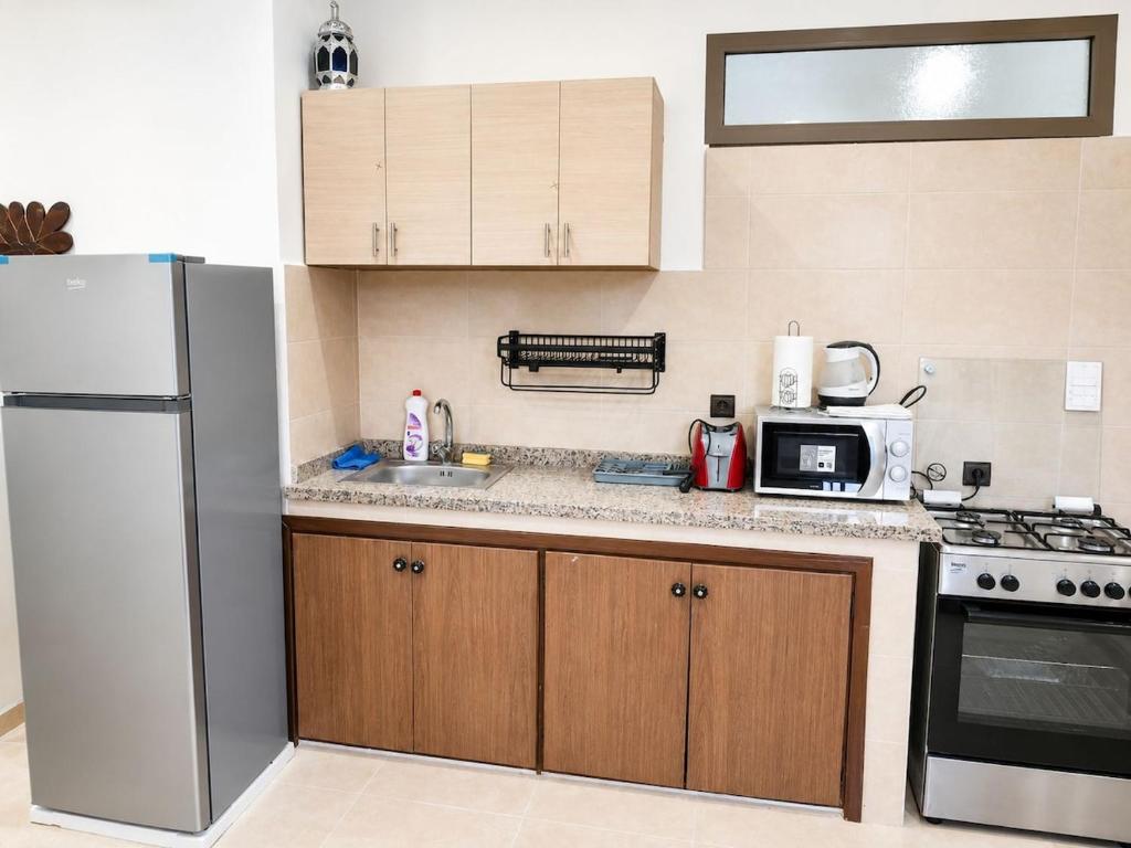 a kitchen with a refrigerator and a microwave at Cosy in Marrakesh