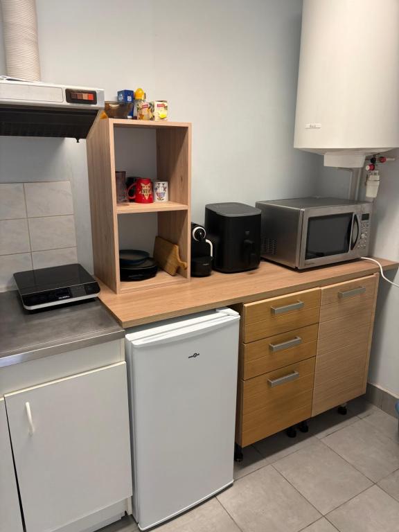 a kitchen with a counter with a microwave and a refrigerator at Bolbec Église in Bolbec