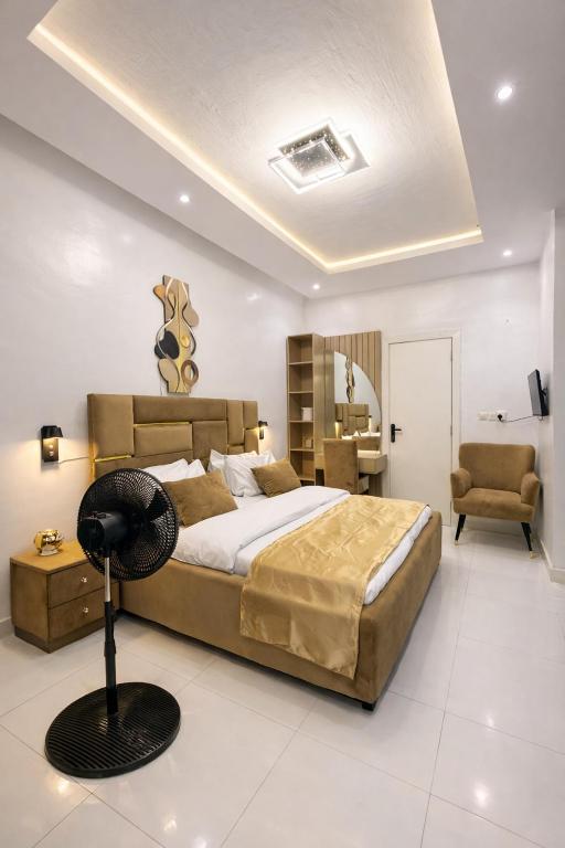 a bedroom with a large bed and a chair at DipNik Residence in Lagos