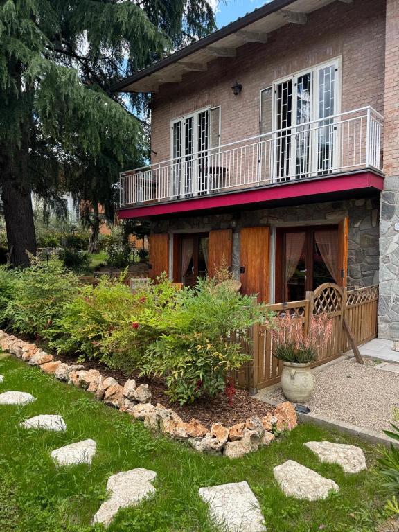 a house with a balcony on top of a yard at B&B Borgo dei Cedri in Pontecchio