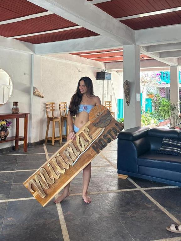 a pregnant woman in a bikini holding a skateboard at Milimar Hostal in San Onofre