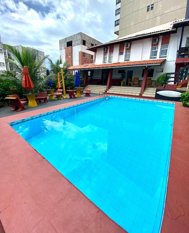 a large blue swimming pool in front of a building at RioVermelhopoint in Salvador