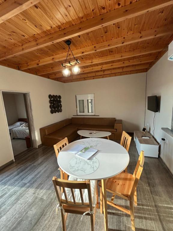 a dining room with a white table and chairs at Liberty Home Μάκρη in Alexandroupoli