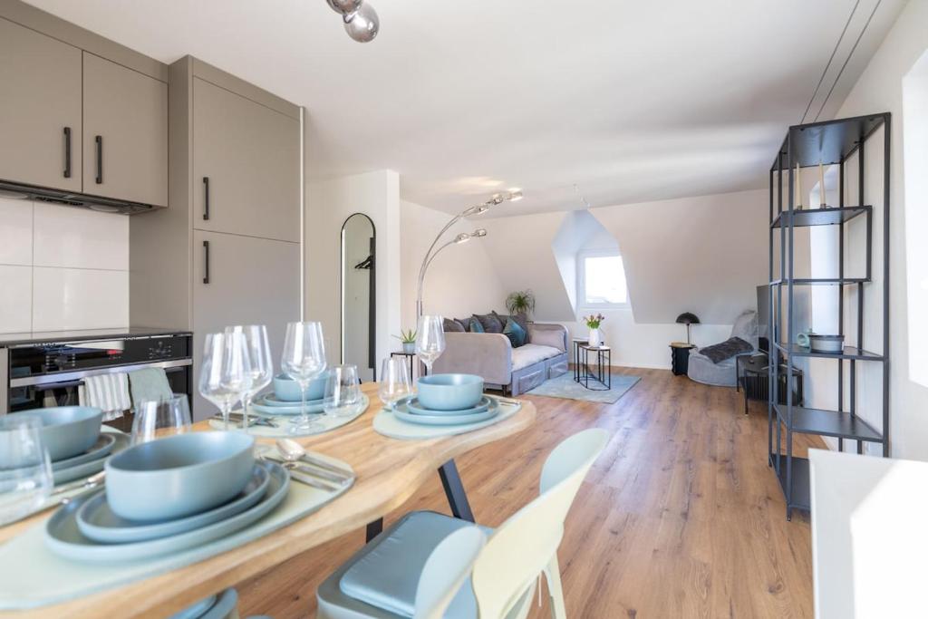 a kitchen and living room with a table and chairs at Sali Suite - Modern Attic Stay in Arbon