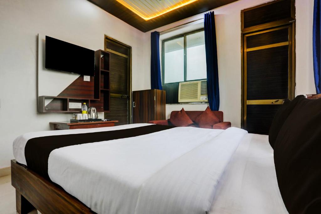 a bedroom with a large bed and a television at HOTEL O MJ INN in Darbhanga