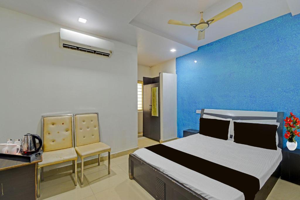 a bedroom with a bed and a blue wall at Hotel O Madhuram Lodge in Siddipet