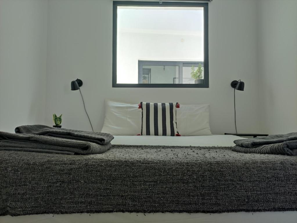 a bedroom with a bed with pillows and a window at Estoril Sun in Estoril