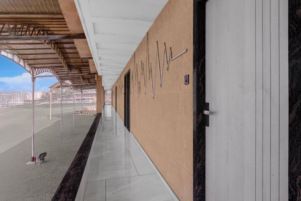 an empty hallway of a building with graffiti on the wall at Hotel O Dwarkadhish in Surat