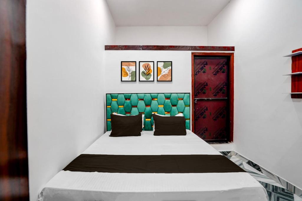 a bedroom with a large bed with a green headboard at Hotel O Shiv Shakti Inn in Sangrāmgarh