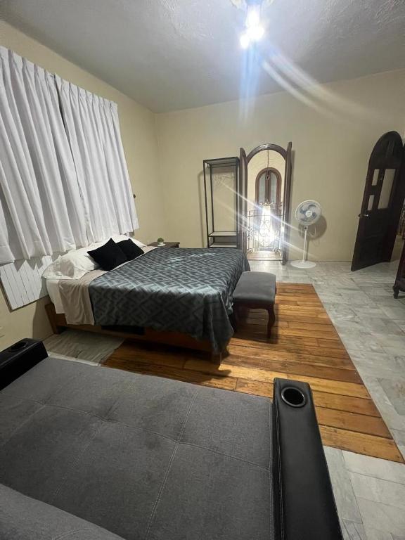 a bedroom with a bed and a fan and a spotlight at Habitación 4 Casa Minerva in Puebla