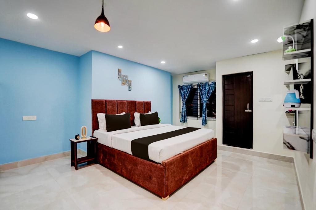 a bedroom with a large bed with blue walls at Hotel O Khusi Tranquil Domicile in Bhubaneshwar