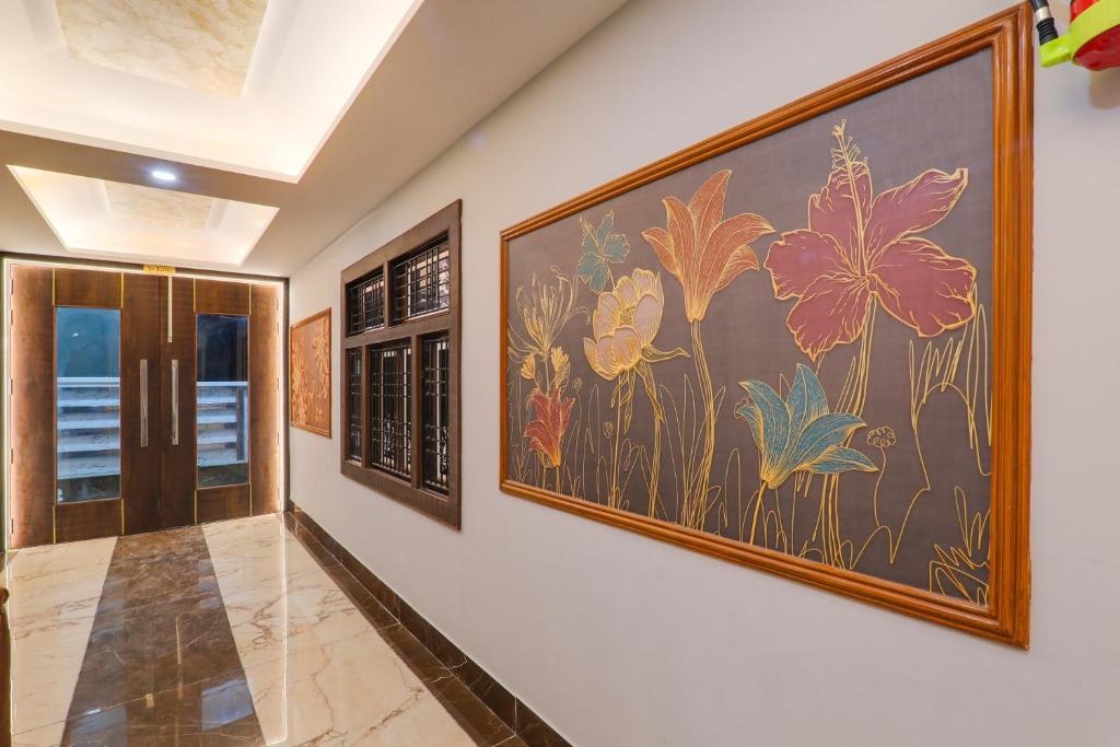 a hallway with a large painting of flowers on the wall at HOTEL O PRAGATI in Gorakhpur