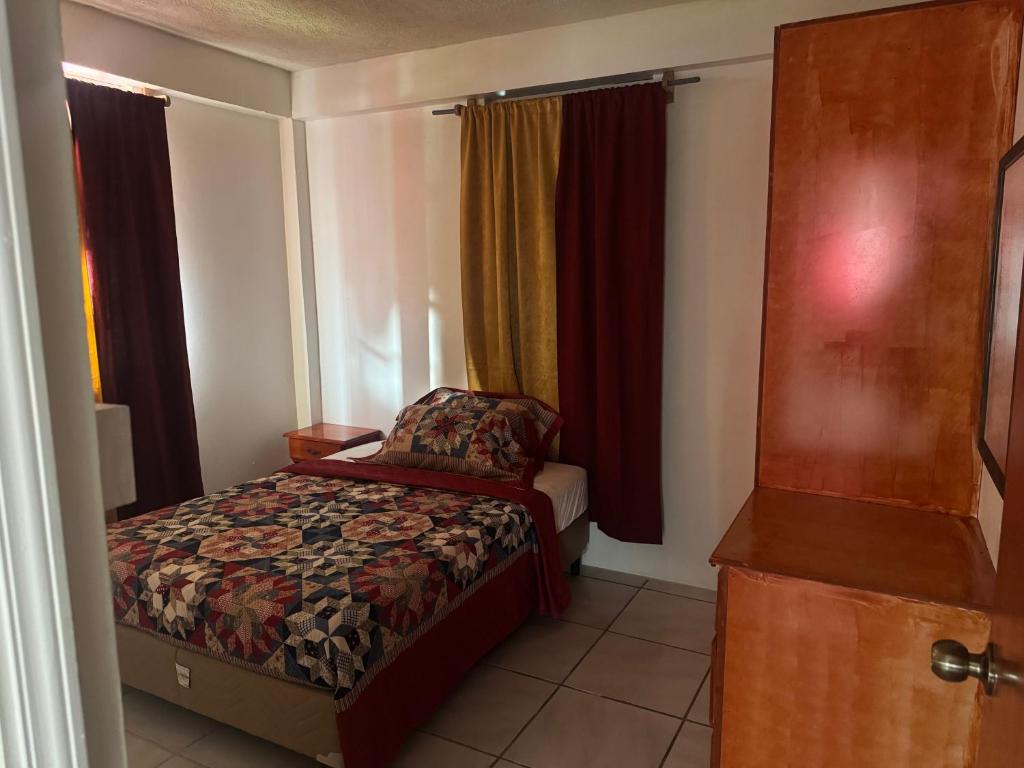 a small bedroom with a bed and a window at Hillside Haven in Cochrane