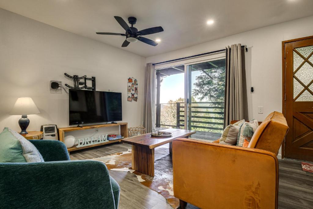 a living room with a flat screen tv and furniture at 2 Mi to Lake Gregory! Chic Crestline Base Camp in Crestline