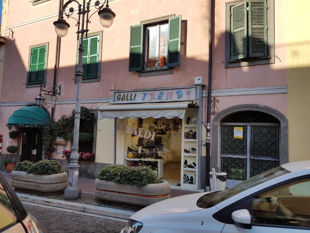 różowy budynek z małym sklepem mody na ulicy w obiekcie Casa vacanza Furlani w mieście Grottaferrata