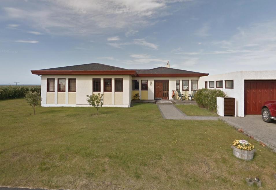 a house with a grass yard in front of it at North Street Sandgerði in Sandgerði