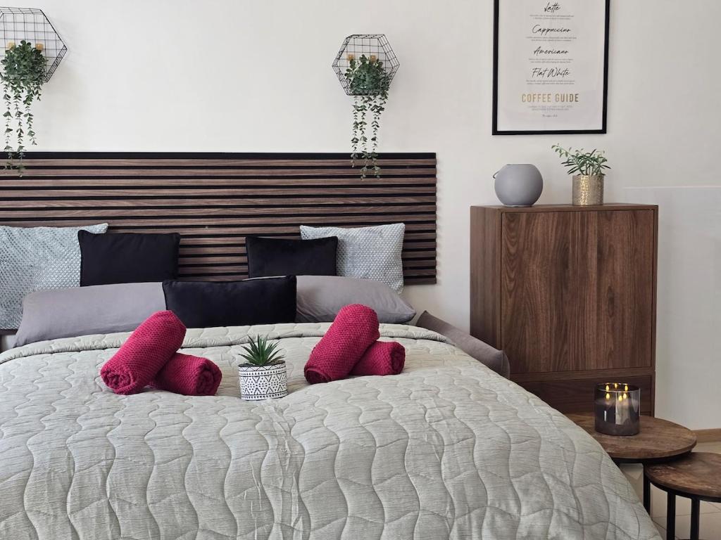 a bedroom with a bed with pink pillows on it at Erdgeschoss Juwel direkt hinter dem Markt I Terrasse & Parkplatz I ruhig & privat in Viersen