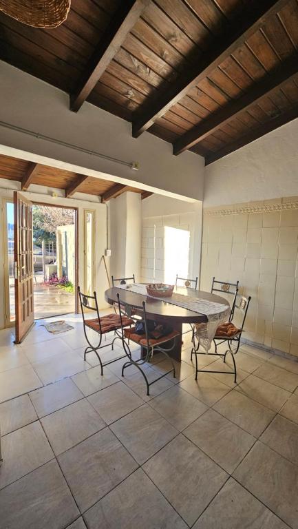 a dining room with a table and chairs on a tile floor at Bell Ville in Bell Ville