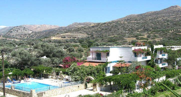 a resort with a swimming pool and a mountain at Armonia Hotel in Matala