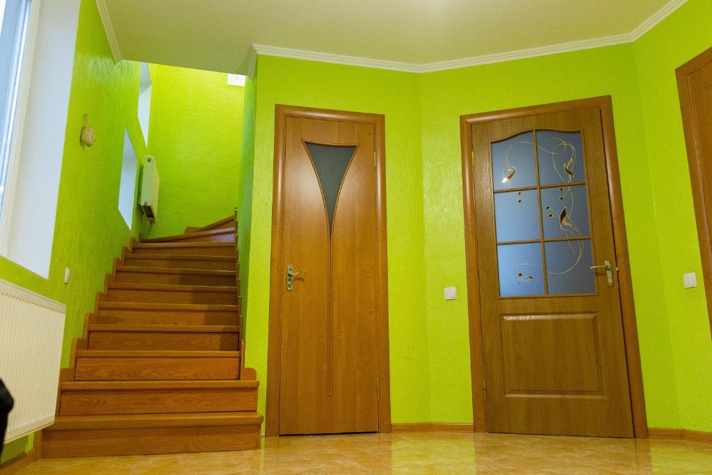duas portas e escadas num quarto com paredes verdes em Vacation home Lubov em Kamianets-Podilskyi