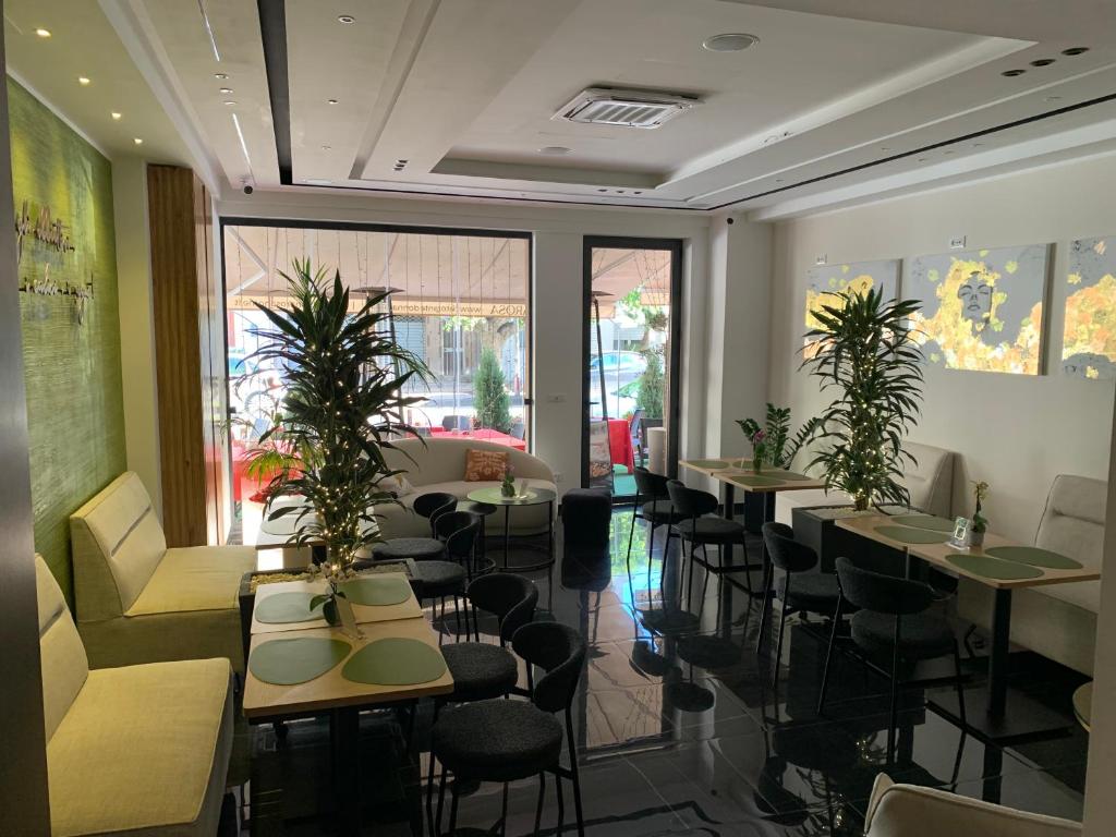 a restaurant with tables and chairs and plants at DonnaRosaHOME in Oliveri
