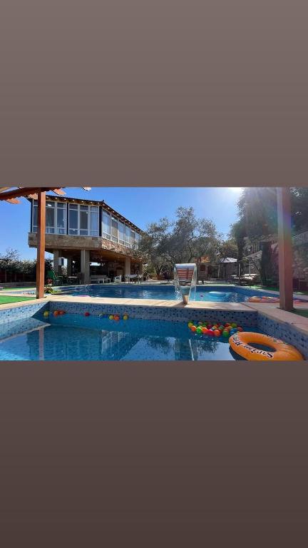 a large swimming pool with a basketball hoop at Bab al-qalaa farm & chalets مزرعة وشاليهات باب القلعه in Ajloun
