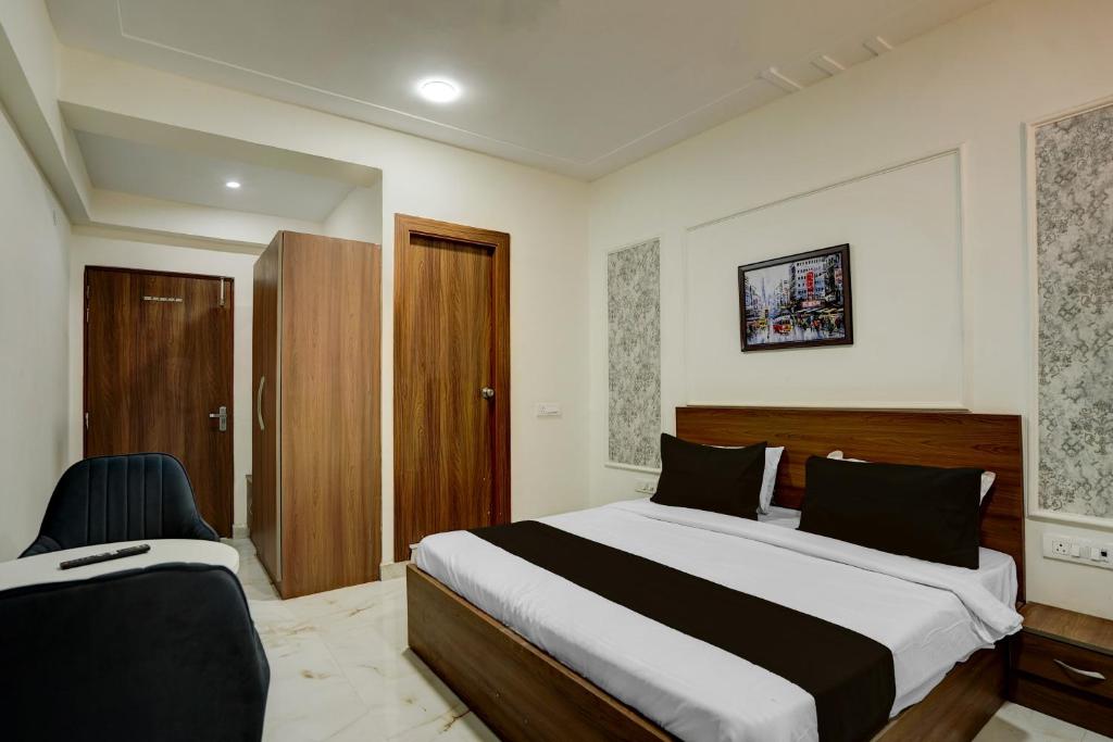 a bedroom with a large bed and two chairs at Super Townhouse Rosens hotel in Noida