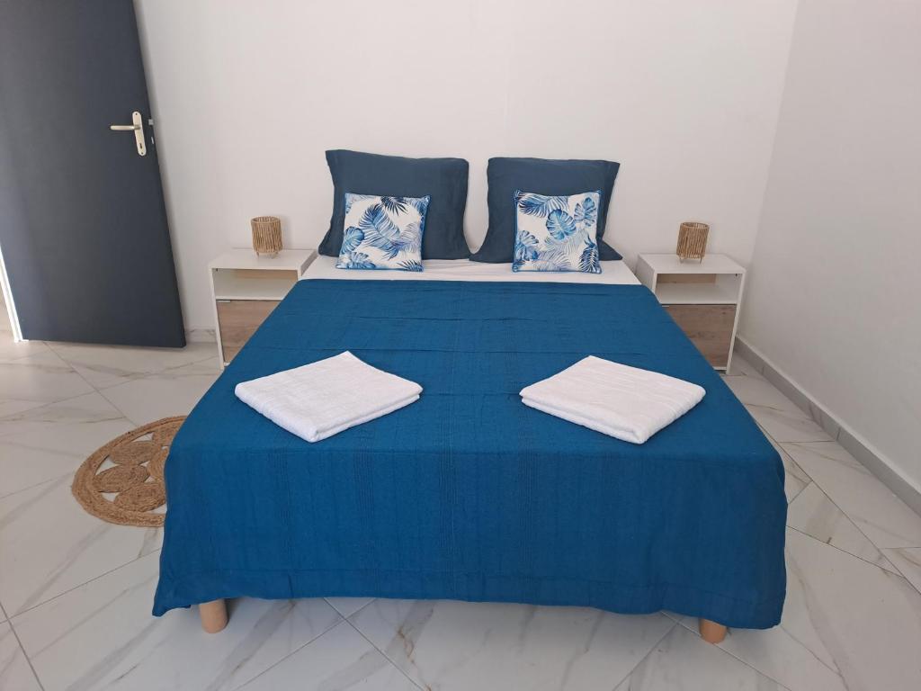 a blue bed with two pillows on top of it at La Casamarie in Saint-Louis