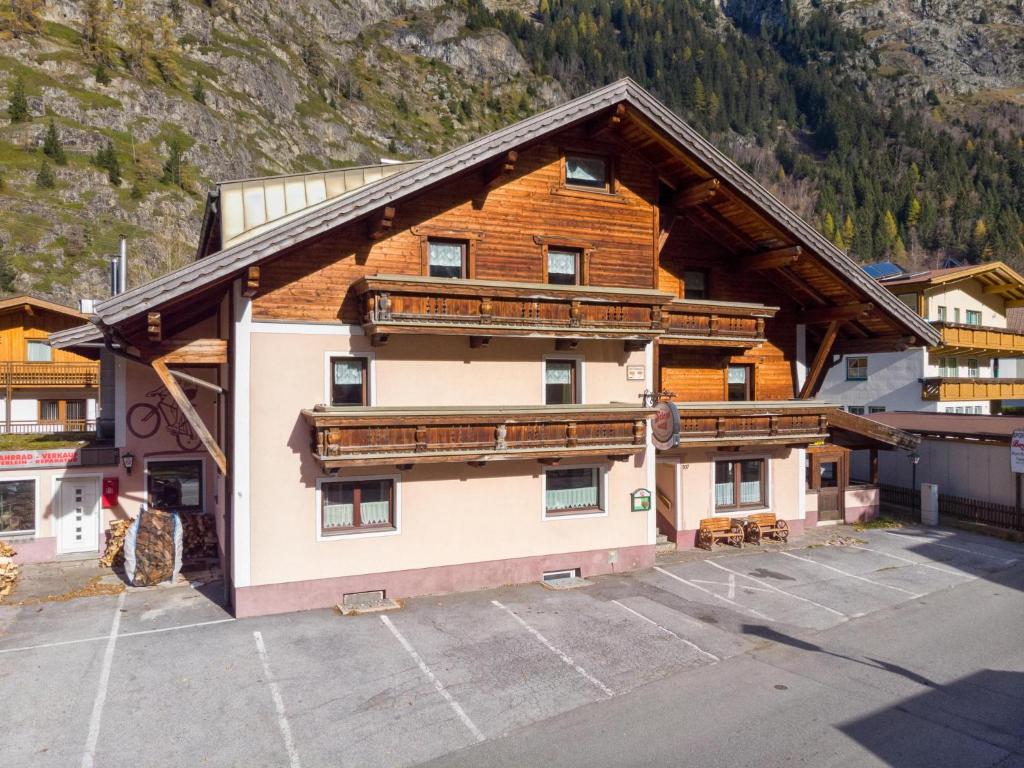 an apartment building with a parking lot in front of a mountain at Bergheimat S in Huben