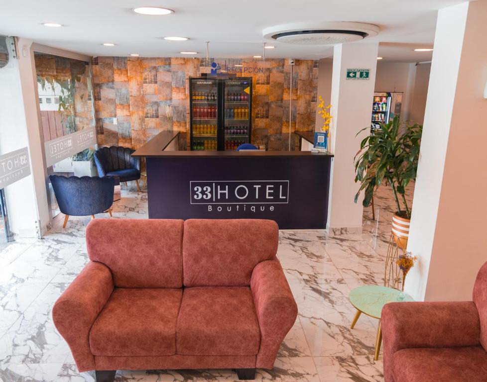 a waiting room with a couch and a counter at 33 HOTEL BOUTIQUE in Medellín