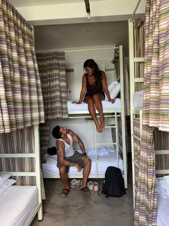 a man and a woman sitting on top of a bunk bed at Hostal Don Cenobio in Flores