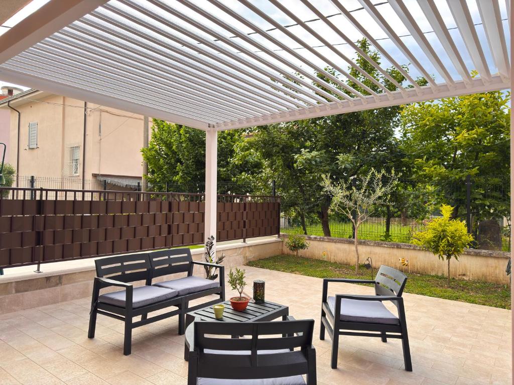 a patio with a pergola and chairs and a table at Assisi valley - Modern Apartment with Covered Parking in Bastia Umbra