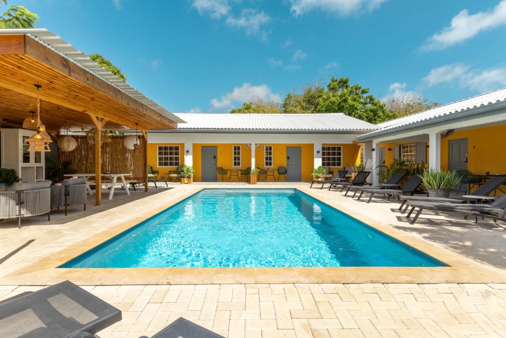 a swimming pool in front of a house at J&L Resort in Willemstad