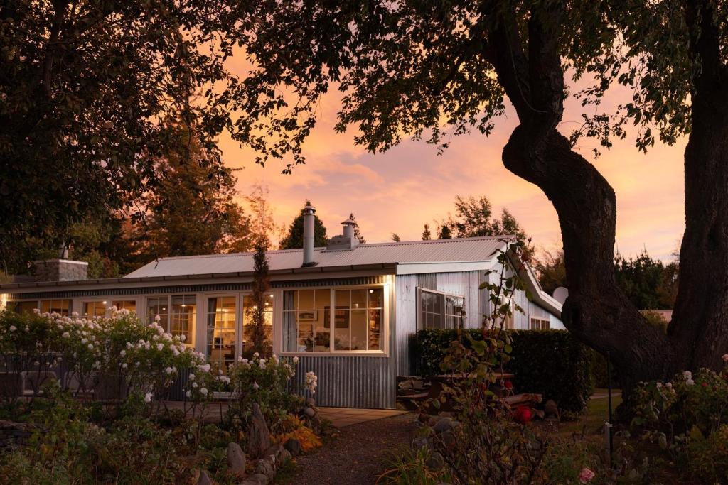 a house with a lot of windows and a tree at Aldourie Lodge - Lake Tekapo in Lake Tekapo