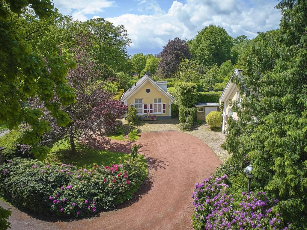 a house with a garden with flowers in front of it at Wellnesshuisje Kalheupink in Oldenzaal