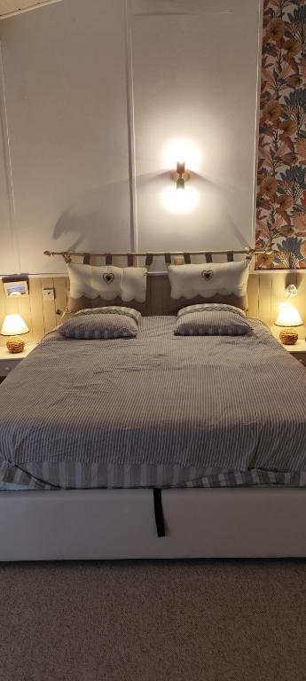 a bedroom with a large bed with two pillows at Teranga in Artigues