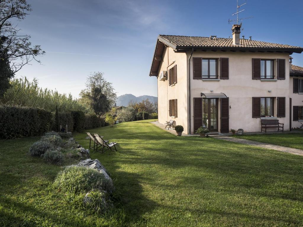 une grande maison avec une cour herbeuse devant elle dans l'établissement Locanda Castel De Britti, à San Lazzaro di Savena