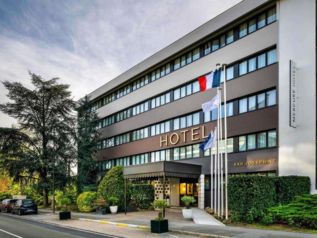 a hotel with flags in front of a building at Mercure Versailles Paris Ouest in Versailles