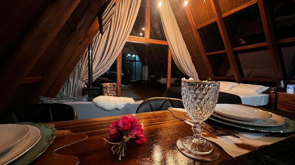 ein Holztisch mit Tellern und einem Weinglas darauf in der Unterkunft Cabanas do vale in Itaquá