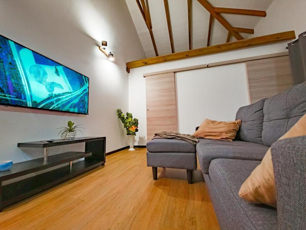 a living room with a couch and a flat screen tv at L'écrin d'Amaroa in Fort-de-France