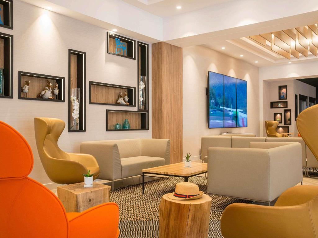 a waiting room with couches and chairs at Novotel Nice Arenas Aeroport in Nice