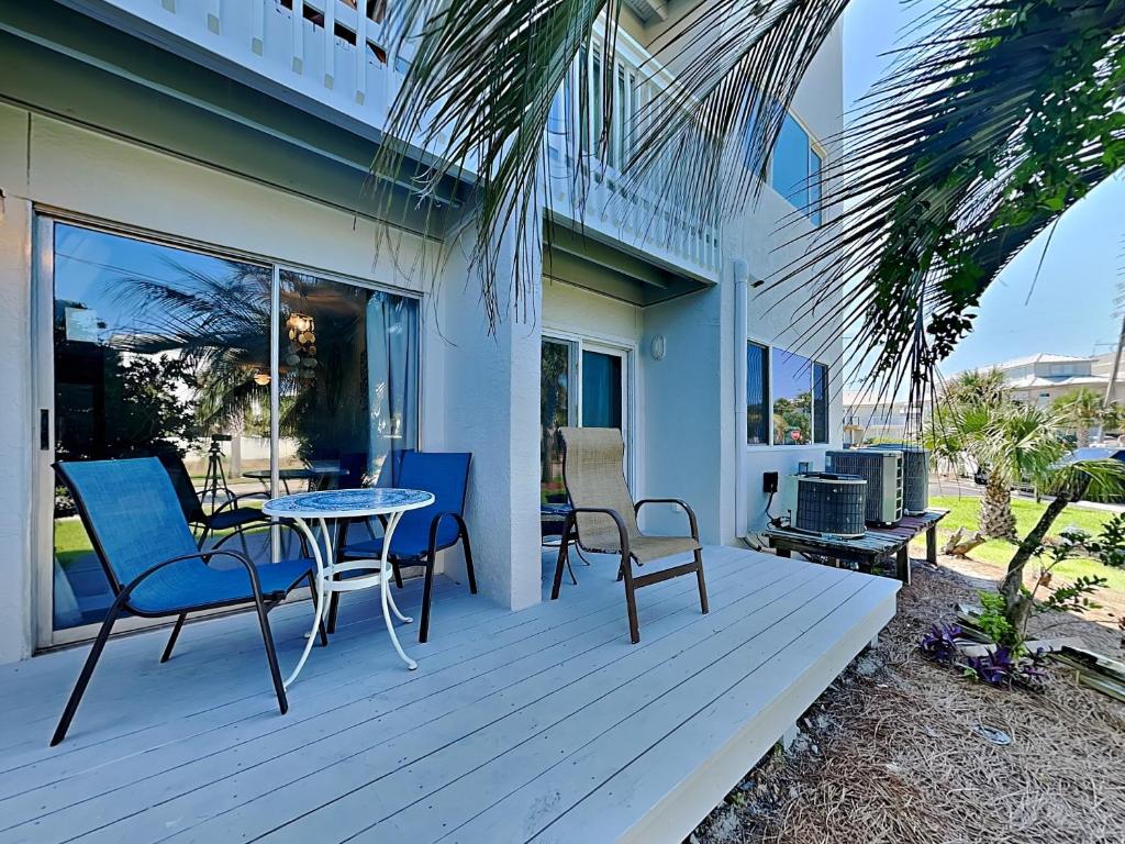 a patio with chairs and a table on a porch at Island Home 102 in Destin