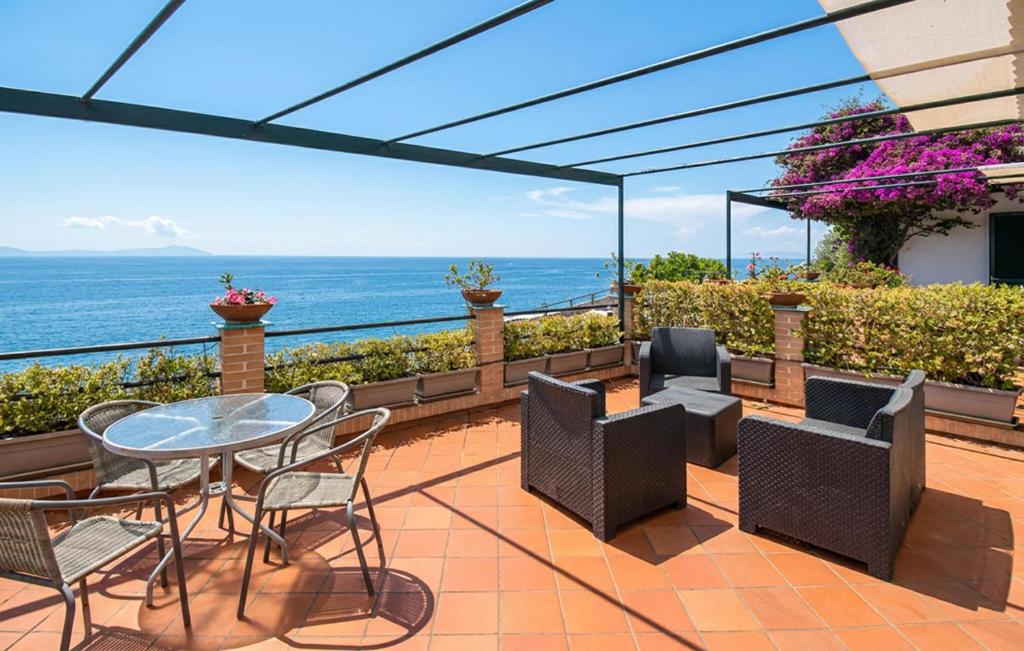 a patio with a table and chairs and the ocean at Oleandri in Vietri sul Mare