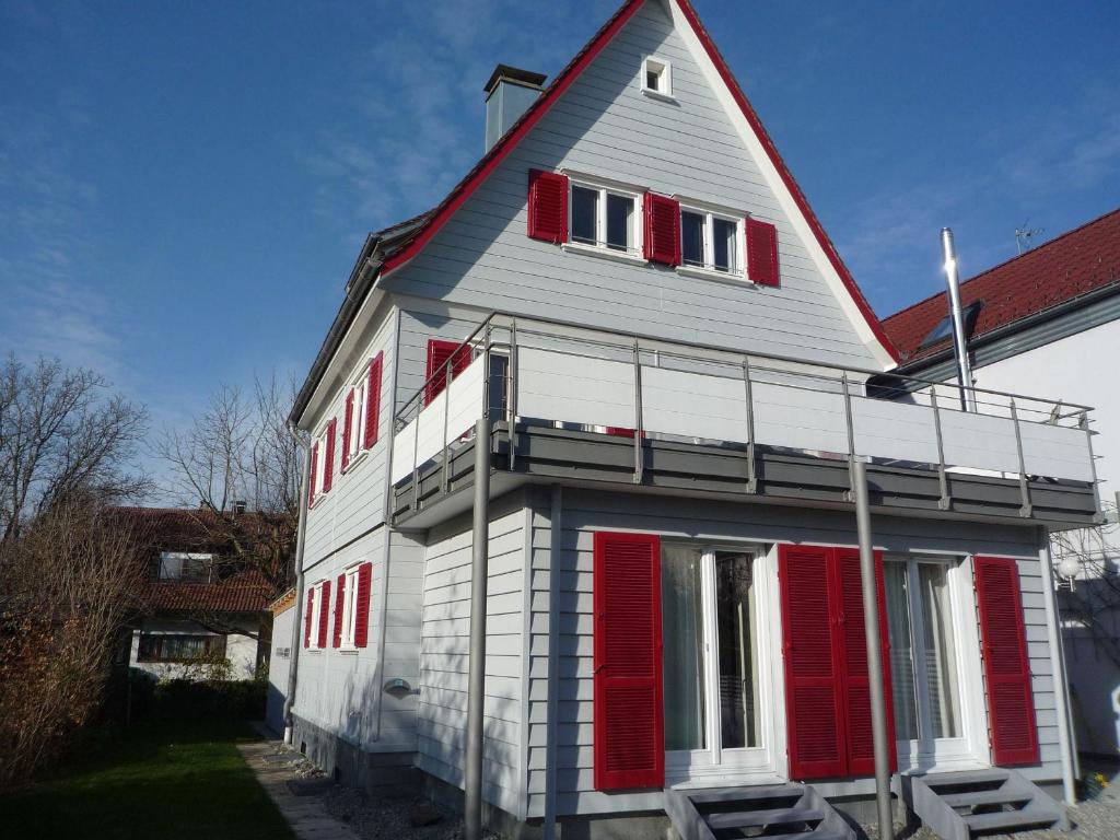 uma casa com persianas vermelhas ao lado dela em Ferienhaus Villa Kunterbunt em Lindau